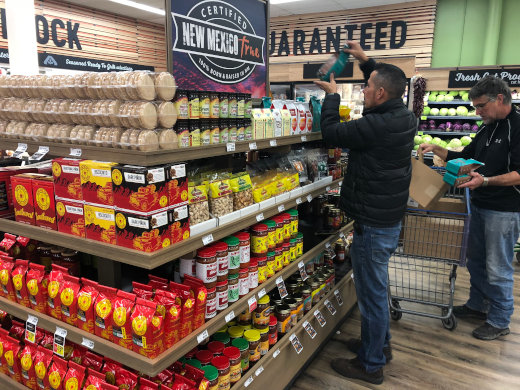 man stocking grocery shelves